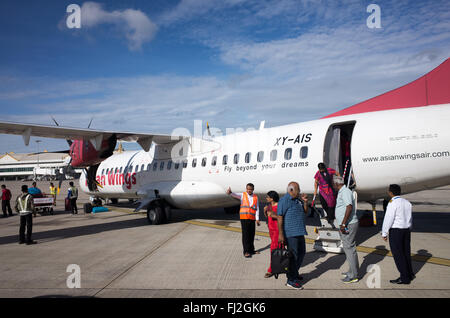 MANDALAY, Myanmar - An Asian Wings plane unloads its passengers on the tarmac of Mandalay Airport, Myanmar (Burma). Stock Photo