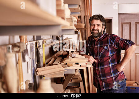 Carpentry business owner standing smiling in his workshop Stock Photo