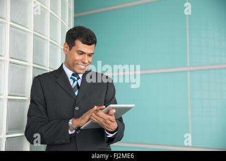 Happy Indian business man using his digital Tablet device. Stock Photo