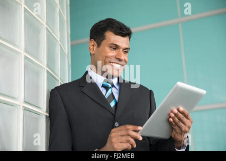 Happy Indian business man using his digital Tablet device. Stock Photo