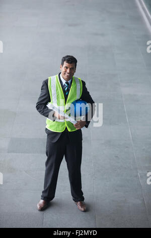 High angle view of an Indian Architect or industrial engineer at work using phone. Stock Photo