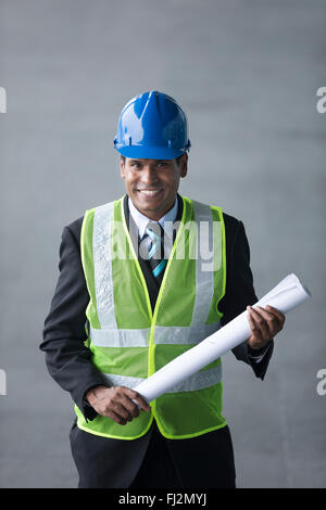 High angle view of an Indian Architect or industrial engineer at work using phone. Stock Photo