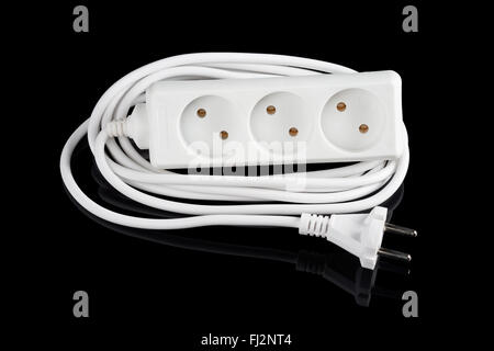 White plastic electrical outlet extension isolated on black reflecting background Stock Photo