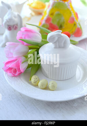 Easter holiday table setting with bunny from egg on white plate and ...