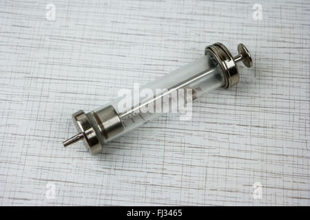 Glass syringe on white table Stock Photo