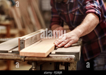 Plank of wood being cut with circular saw in workshop Stock Photo