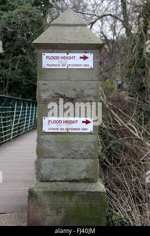 Flood marker on a footbridge over the River Derwent at Hall Leys Park in Matlock Stock Photo