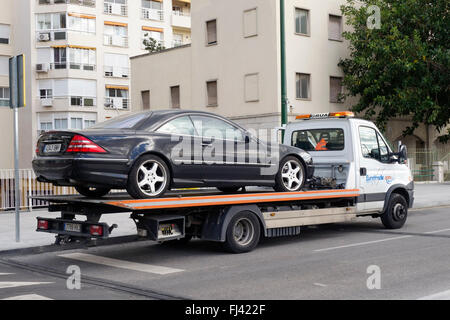 Luxury car on flatbed tow truck, Spain. Stock Photo