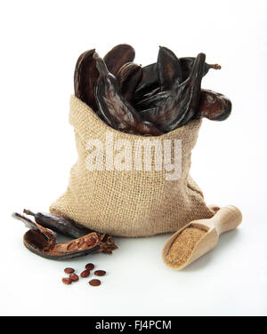 Carob pods and grains isolated on white background Stock Photo