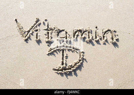 'Vitamin D' handwritten in sand beach Stock Photo