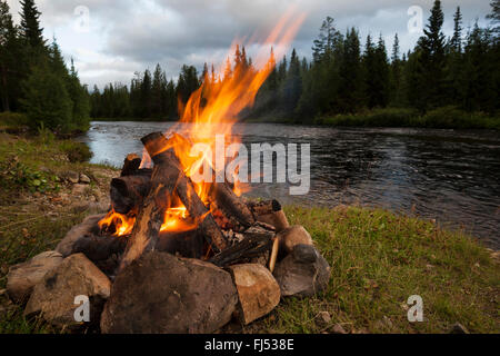 bonfire on riverbank, Sweden Stock Photo