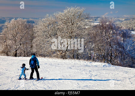father and son skiing on a ski piste of Wildewiese, Germany, North Rhine-Westphalia, Sauerland, Sundern Stock Photo