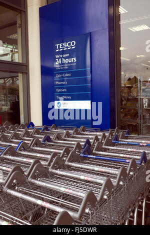 trolleys lined up outside tesco store at handforth dene shopping outlets Stock Photo