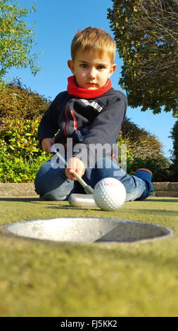 miniature golf, miniature golf ball is holed by a boy, Germany Stock Photo