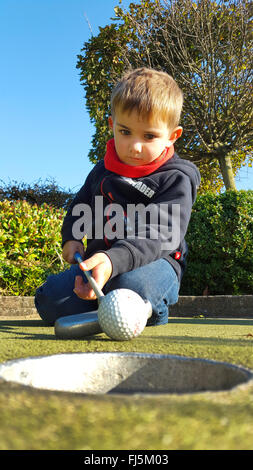 miniature golf, miniature golf ball is holed by a boy, Germany Stock Photo