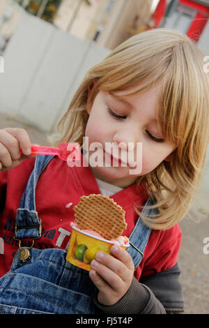 little boy eating appreciatively an ice cream, Germany Stock Photo