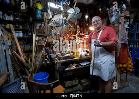 guy in a workshop toolshed with a billiard cue, Argentina Stock Photo