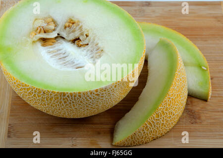 A Galia melon on a wooden chopping board.