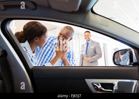 excited African couple at the dealership buying new car Stock Photo