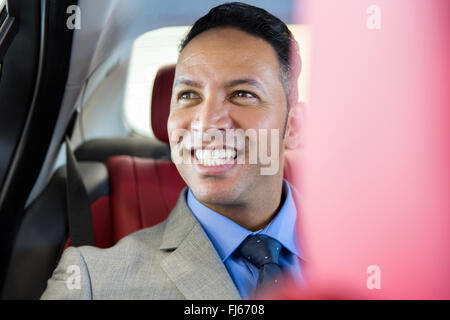 handsome middle aged businessman sitting on the backseat in a car Stock Photo