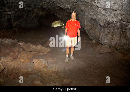 ID00465-00...IDAHO - Exploring Beauty Cave, a lava tube, with a flashlight at Craters of the Moon National Monument and Preserve Stock Photo