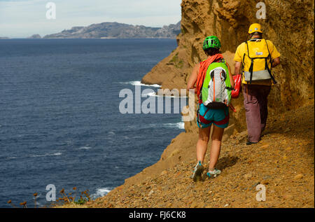 two hikers at the bottom of coastal rock Bec de l'Aigle, adventure way, France, Provence, Calanques National Park, La Ciotat Stock Photo