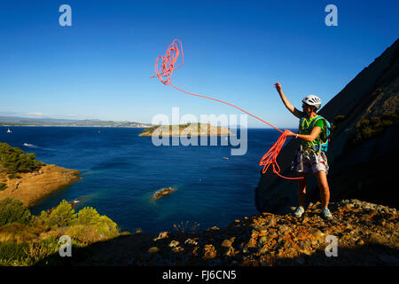 climber throwing a rope at coastal rock Bec de l'Aigle, adventure way, France, Provence, Calanques National Park, La Ciotat Stock Photo