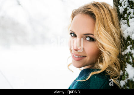 Smiling face of blond woman outside in winter nature Stock Photo