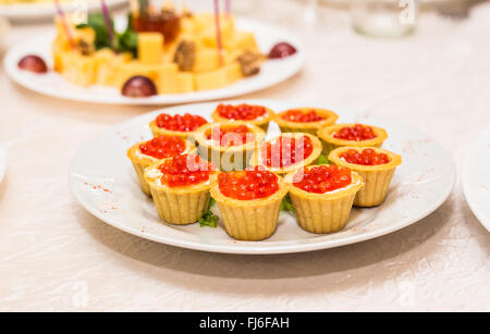Red caviar in tartlets on white plate close-up Stock Photo