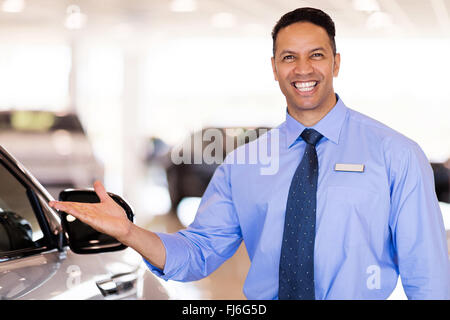 good looking mid age car salesman presenting new cars Stock Photo