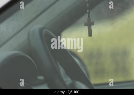 Cross hanging from the rear view mirror Stock Photo