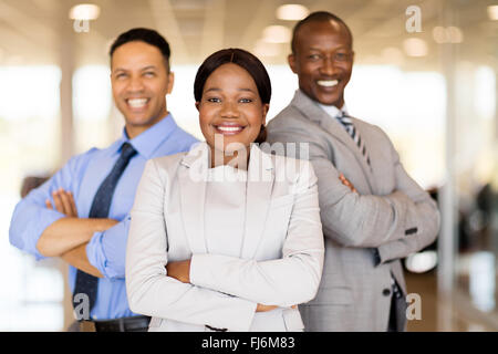 multiracial vehicle sales team with arms crossed inside car showroom Stock Photo