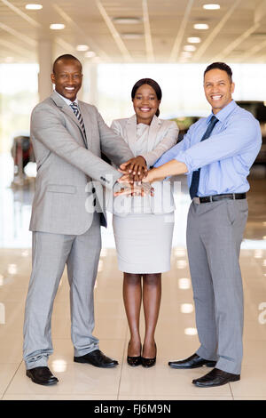 multiracial car dealership staff putting their hands together Stock Photo