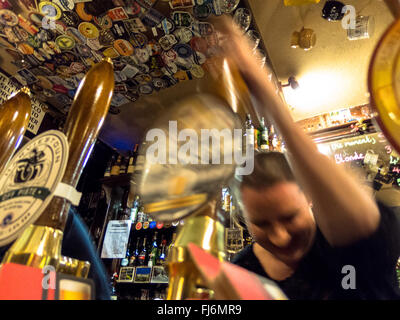 Bar staff pulling a pint of beer from the draught beer pump in a pub in Edinburgh, Scotland Stock Photo