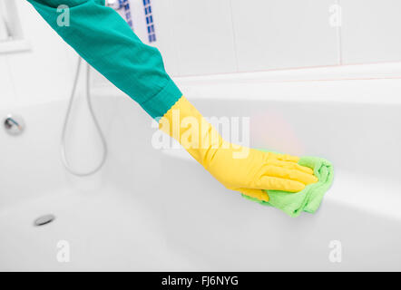 Hand in yellow glove washes sink. Stock Photo