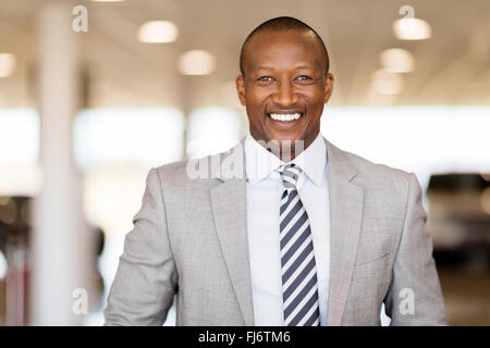 happy African car salesman in showroom Stock Photo