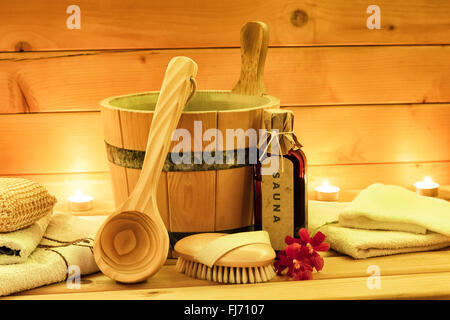 Sauna accessories with sauna oil, wooden bucket, ladle, towels Stock Photo