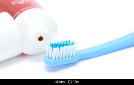 Blue toothbrush and tooth paste tube on white background. Closeup of the daily dental hygiene tool. Stock Photo