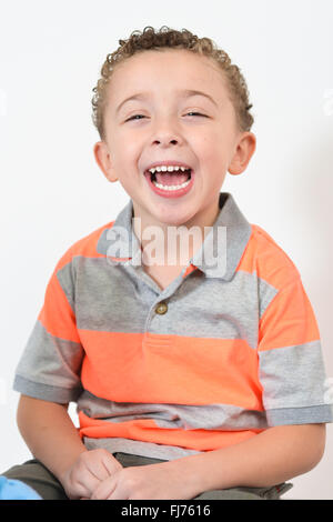 Cheerful boy smiling while posing - against white background. Stock Photo