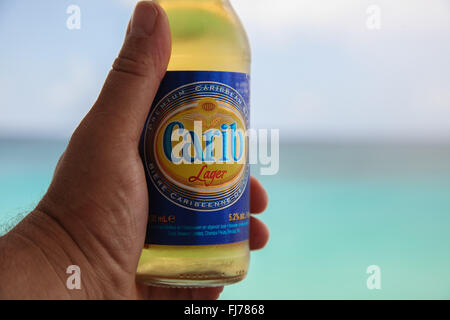 Ice cold Carib beer in mans hand Stock Photo