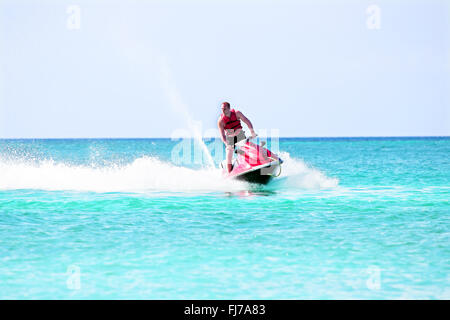 Young guy cruising on a jet ski on the caribbean sea Stock Photo