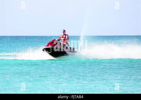 Young guy cruising on a jet ski on the caribbean sea Stock Photo