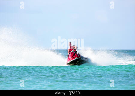 Young guy cruising on a jet ski on the caribbean sea Stock Photo