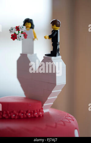 Red and white polka dot wedding cake with Lego Bride and Groom Stock Photo