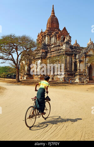 Cyclist at Thatthe Mokgo Hpaya Pagoda in Nuang U, Bagan, Myanmar (Burma) Stock Photo