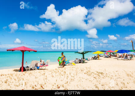 Local woman selling colourful scarves, wraps, sarongs and towels on the beach in Runaway Bay, north Antigua, Antigua and Barbuda Stock Photo