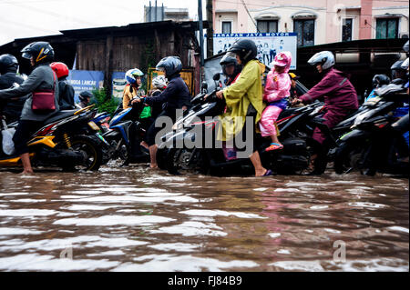 Tangerang, Indonesia. 29th Feb, 2016. Indonesian ride their motorcycles and pass through the flooded road caused by heavy rains in Tangerang. Seasonal rains and high tides in recent days have caused widespread flooding across much in Indonesia. Credit:  Yuan Adriles/Pacific Press/Alamy Live News Stock Photo