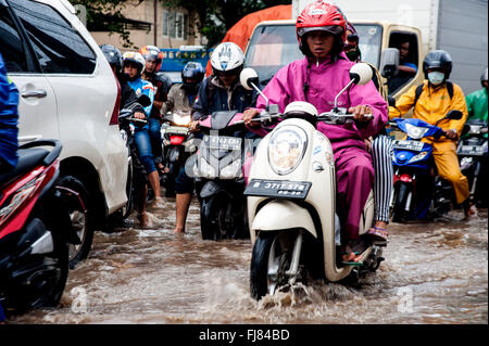 Tangerang, Indonesia. 29th Feb, 2016. Indonesian ride their motorcycles and pass through the flooded road caused by heavy rains in Tangerang. Seasonal rains and high tides in recent days have caused widespread flooding across much in Indonesia. Credit:  Yuan Adriles/Pacific Press/Alamy Live News Stock Photo