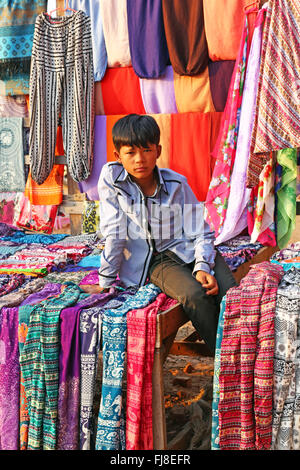 Boy on a trouser and clothing stall at Pyathadar Hpaya Temple Pagoda on the Plain of Bagan, Bagan, Myanmar (Burma) Stock Photo