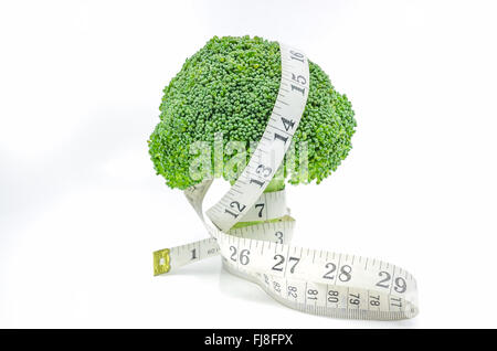 Live Healthy - Fresh raw broccoli with measuring tape on white background. Stock Photo